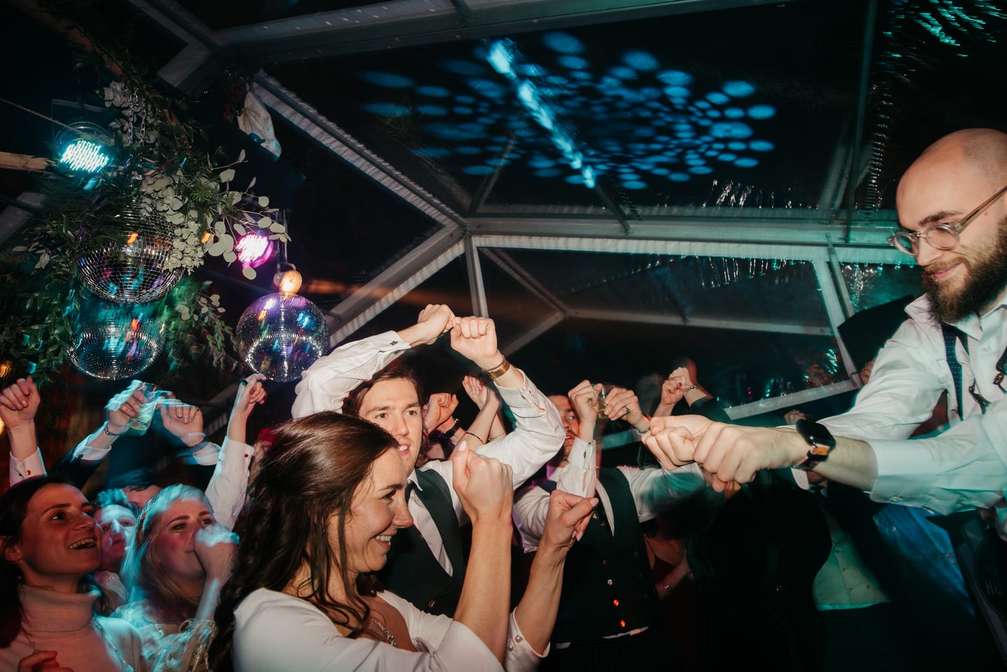 A packed dance floor under the disco balls