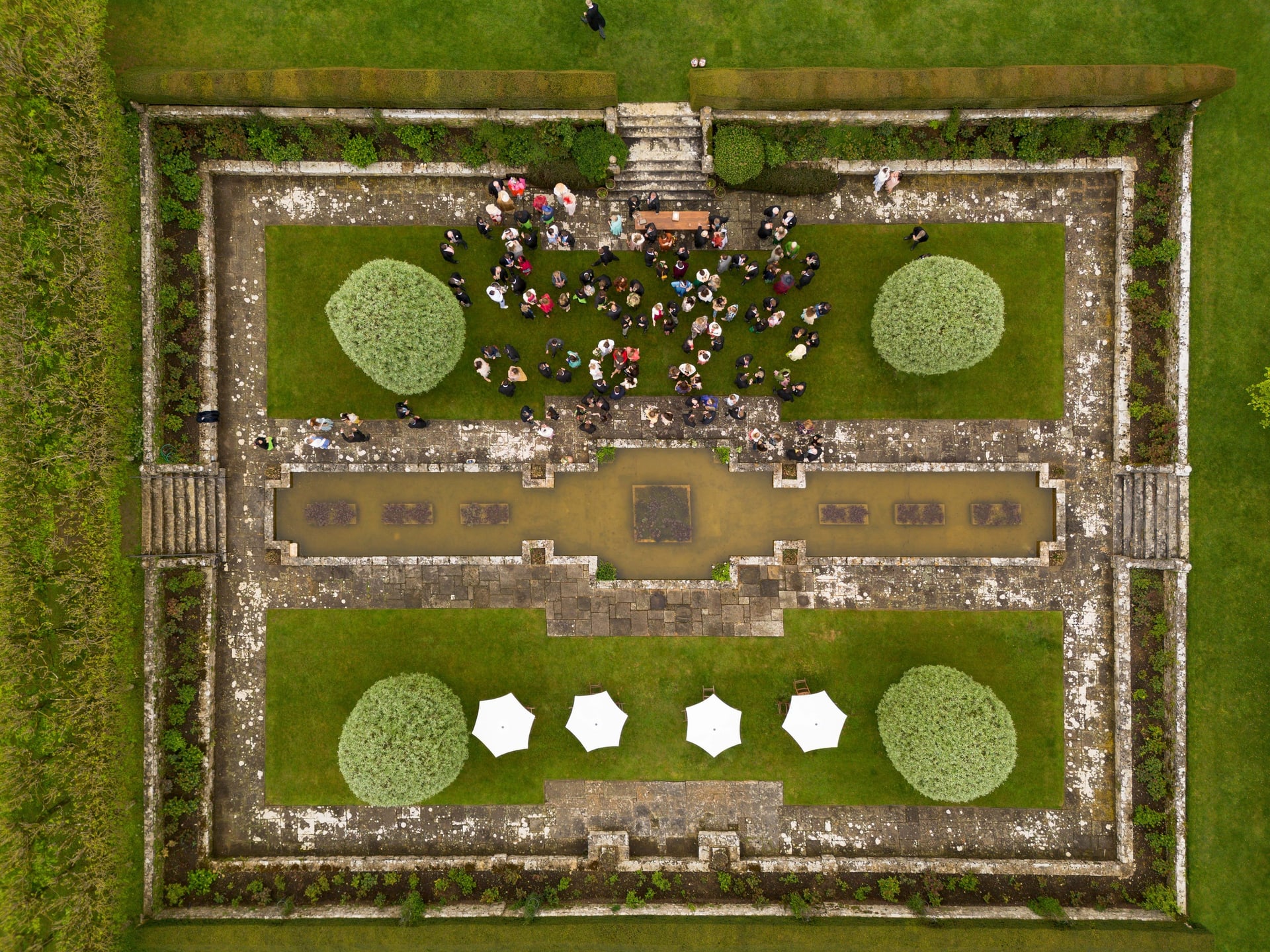 A walled garden from directly above, with guests gathered in the centre