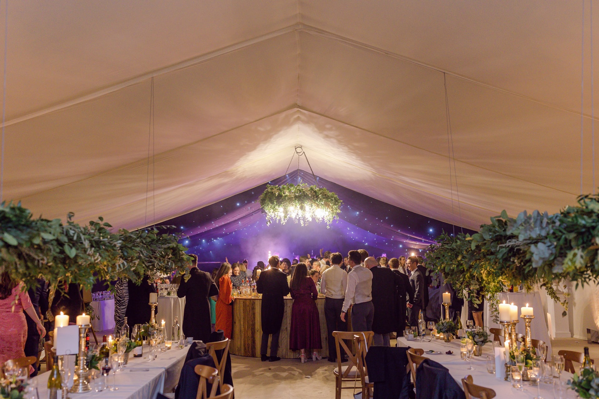 A marquee laid for dinner, with the dance floor and the band at the far end